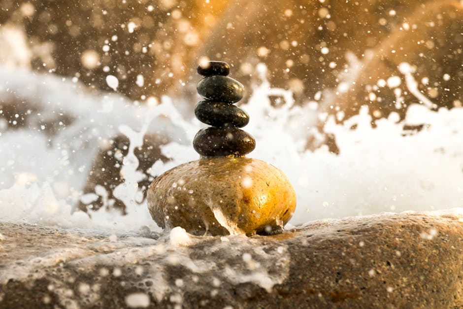 A perfectly balanced stack of smooth stones near calm water